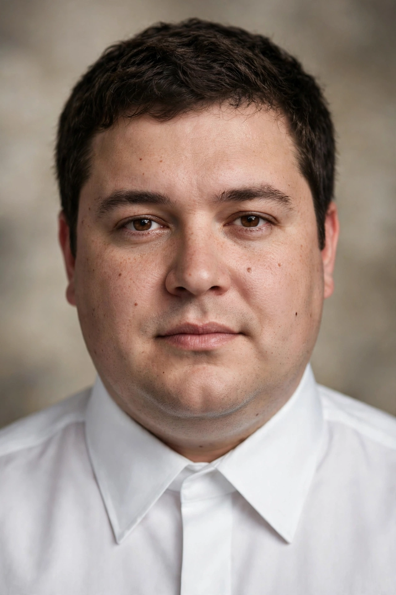 Man with round face wearing a white dress shirt with a sharp pointed collar
